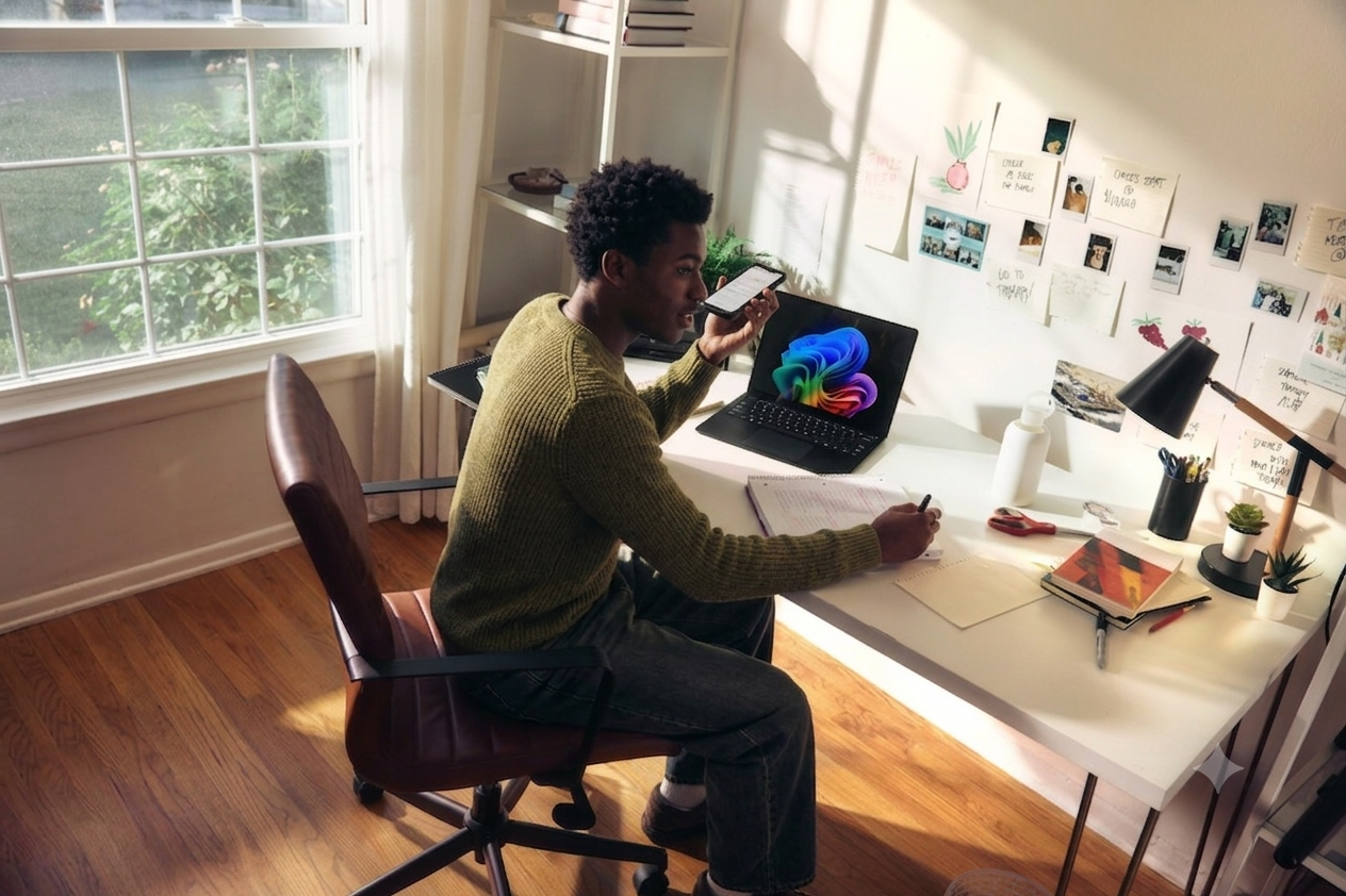 Professional working at a desk with laptop and phone